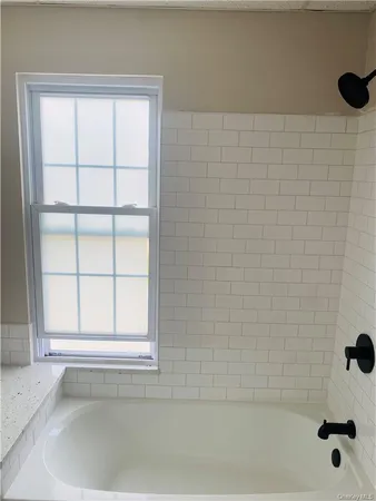 a bathroom with a bathtub and window