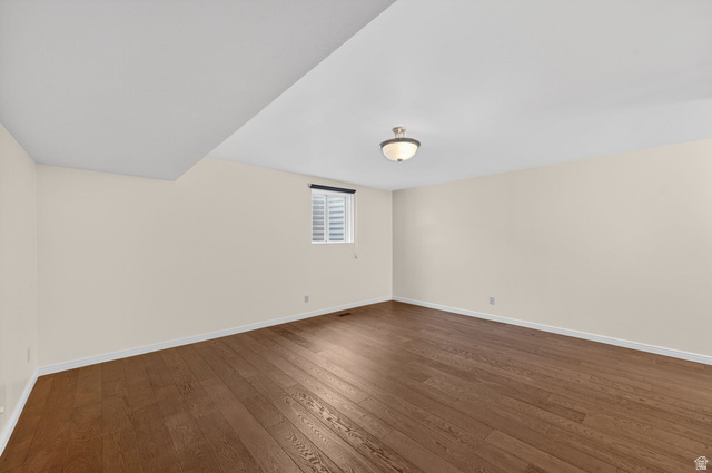 3120 North Apache Way Provo, UT 84604 - Photo 41 of 58 Spacious interior room featuring wood-finish flooring, neutral wall tones, a ceiling-mounted light fixture, and a window with louvered blinds