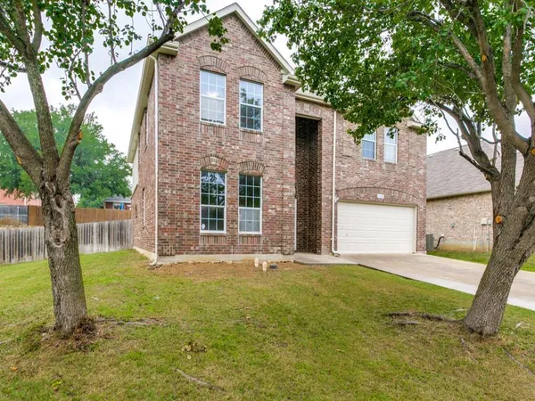 a front view of a house with yard and green space