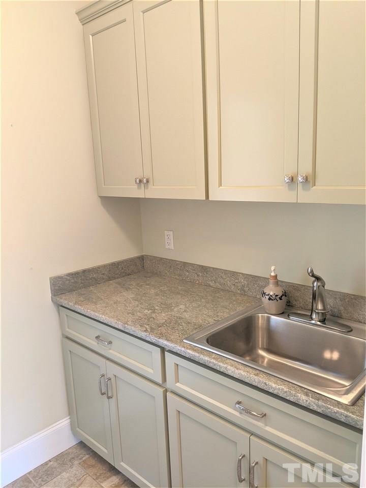 2729 Howard Road Raleigh, NC 27613 - Photo 11 of 26 a kitchen with white cabinets and a sink