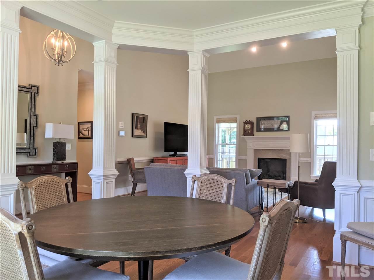 2729 Howard Road Raleigh, NC 27613 - Photo 6 of 26 a living room with furniture a fireplace and a dining table with wooden floor