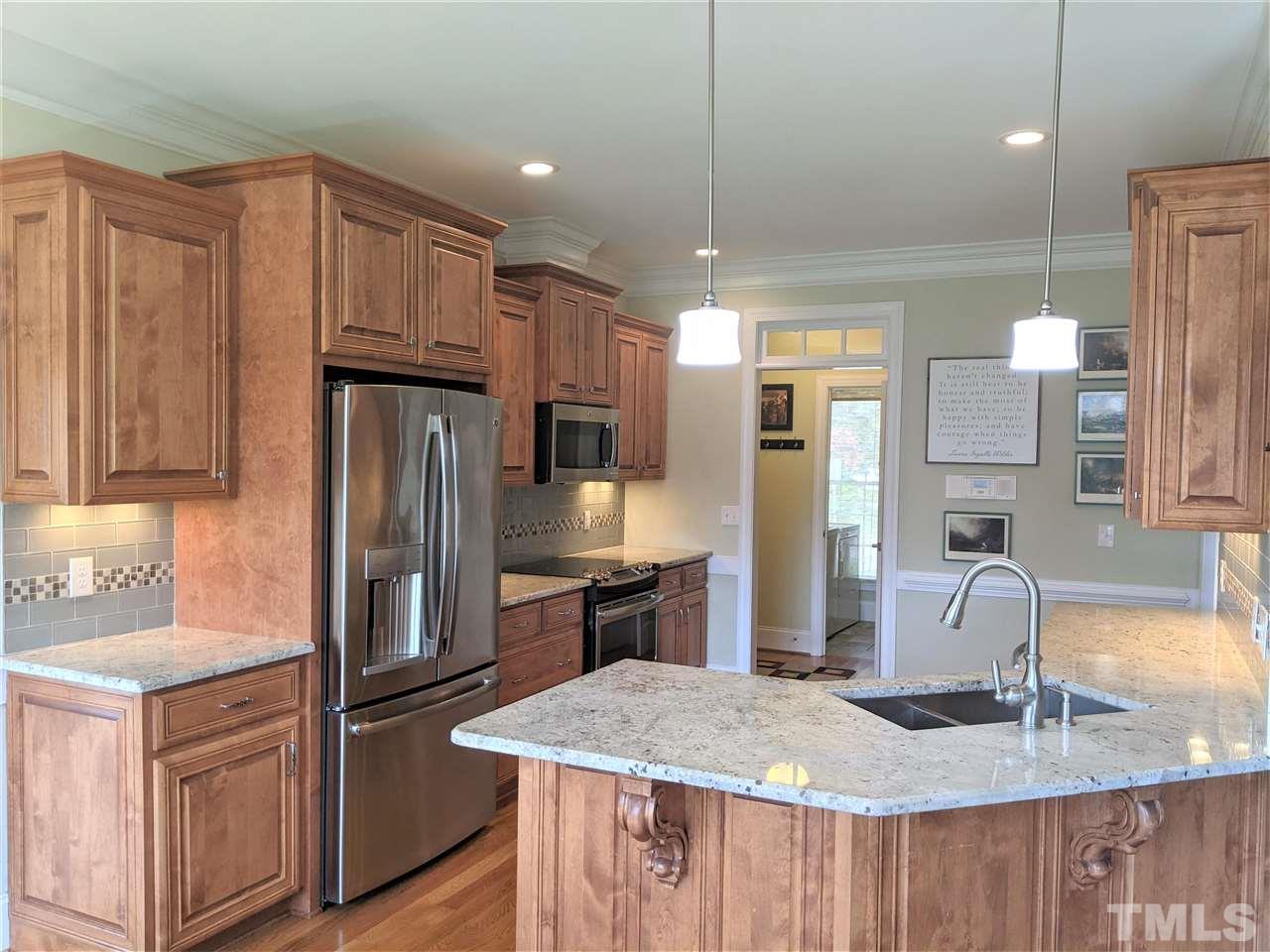 2729 Howard Road Raleigh, NC 27613 - Photo 9 of 26 a kitchen with stainless steel appliances granite countertop a sink refrigerator and cabinets