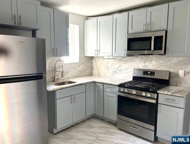 a kitchen with stainless steel appliances a stove a microwave and sink