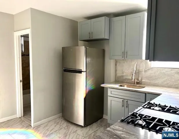 a kitchen with stainless steel appliances granite countertop a refrigerator and a sink