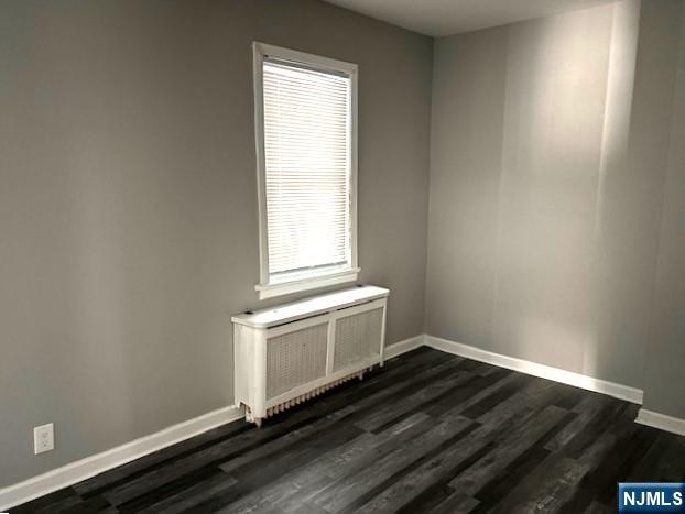 291 Delano Place, Unit 1 Fairview, NJ 07022 - Photo 5 of 7 an empty room with wooden floor and windows