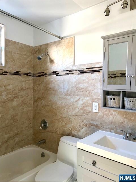 291 Delano Place, Unit 1 Fairview, NJ 07022 - Photo 6 of 7 a bathroom with a granite countertop sink and a mirror