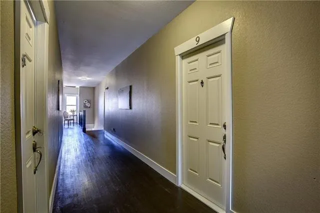 a view of a hallway with wooden floor