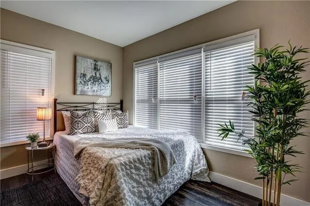 a bedroom with a large bed and a potted plant