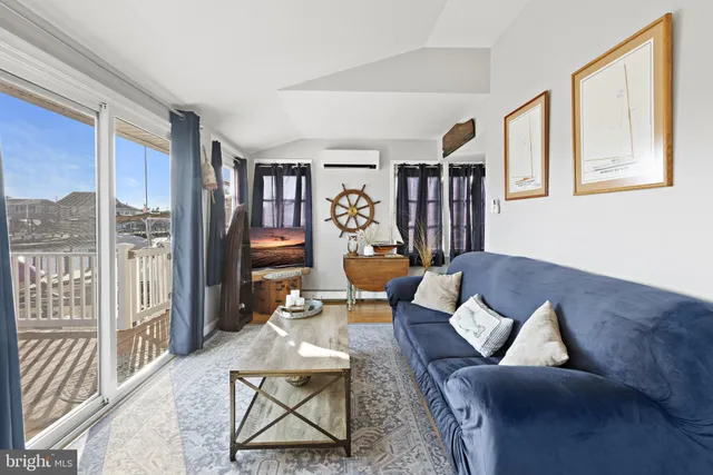 a living room with furniture a rug and a bookshelf