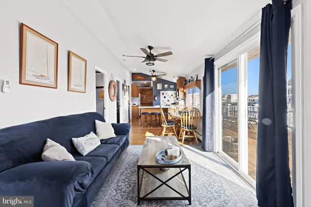 a living room with furniture a ceiling fan and a window