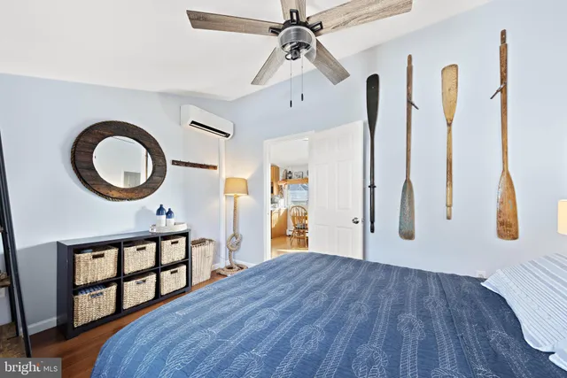 a bedroom with a bed a dresser and paintings on the wall