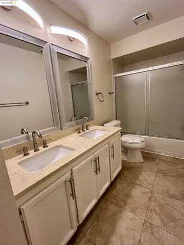 a bathroom with a double vanity sink mirror and toilet