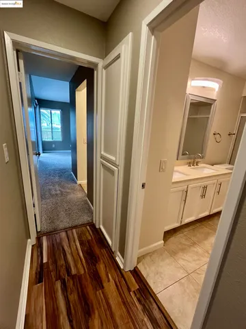 a view of a hallway with wooden floor and entryway