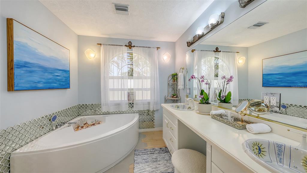3604 Casey Key Road Nokomis, FL 34275 - Photo 32 of 94 a bathroom with a granite countertop sink mirror vanity bathtub and toilet