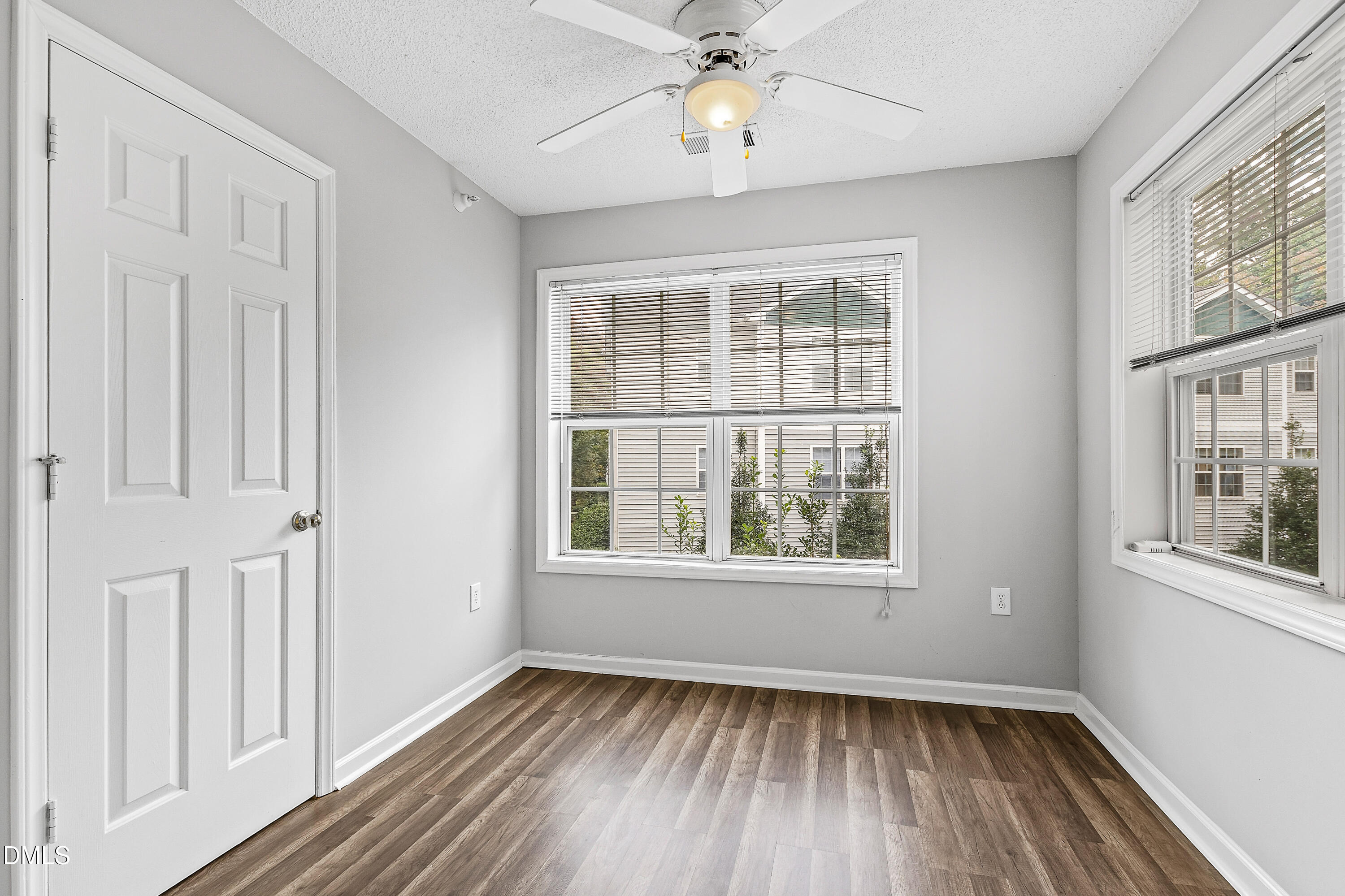 2100 Wolf Tech Lane, Unit 204 Raleigh, NC 27603 - Photo 15 of 40 an empty room with wooden floor fan and windows