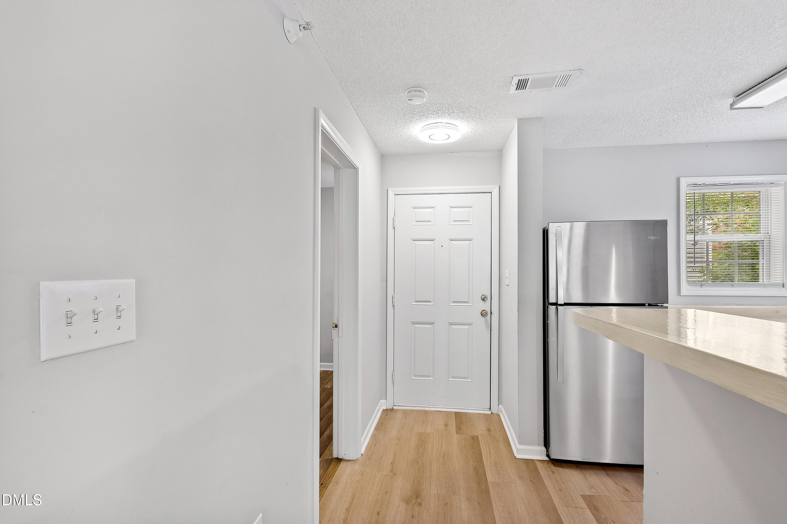 2100 Wolf Tech Lane, Unit 204 Raleigh, NC 27603 - Photo 18 of 40 a view of a kitchen with wooden floor and refrigerator