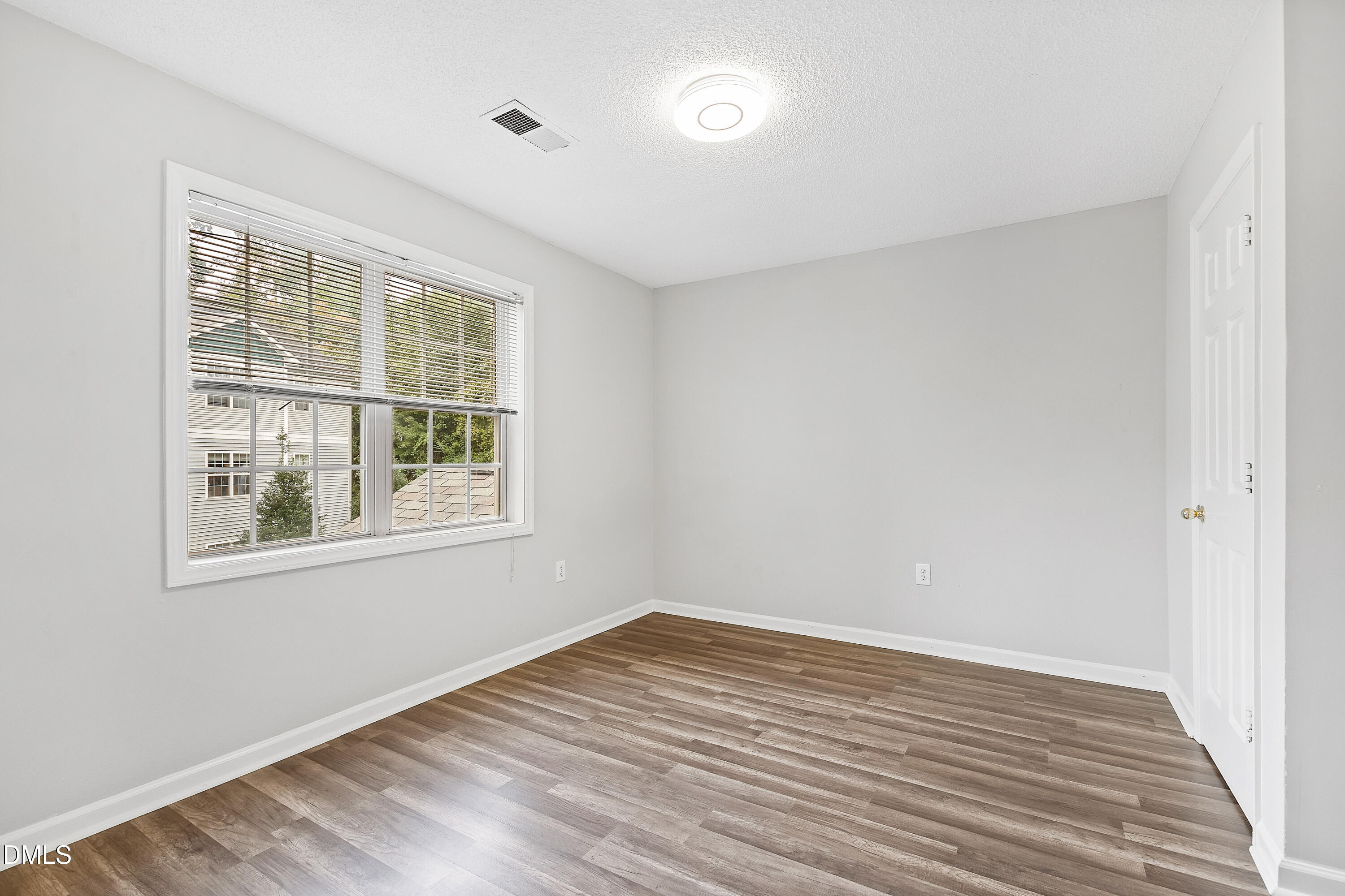 2100 Wolf Tech Lane, Unit 204 Raleigh, NC 27603 - Photo 25 of 40 a view of empty room with wooden floor and fan