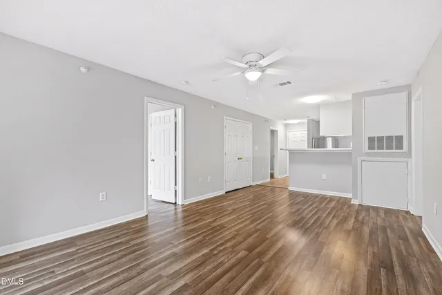 a view of a kitchen with wooden floor and a ceiling fan