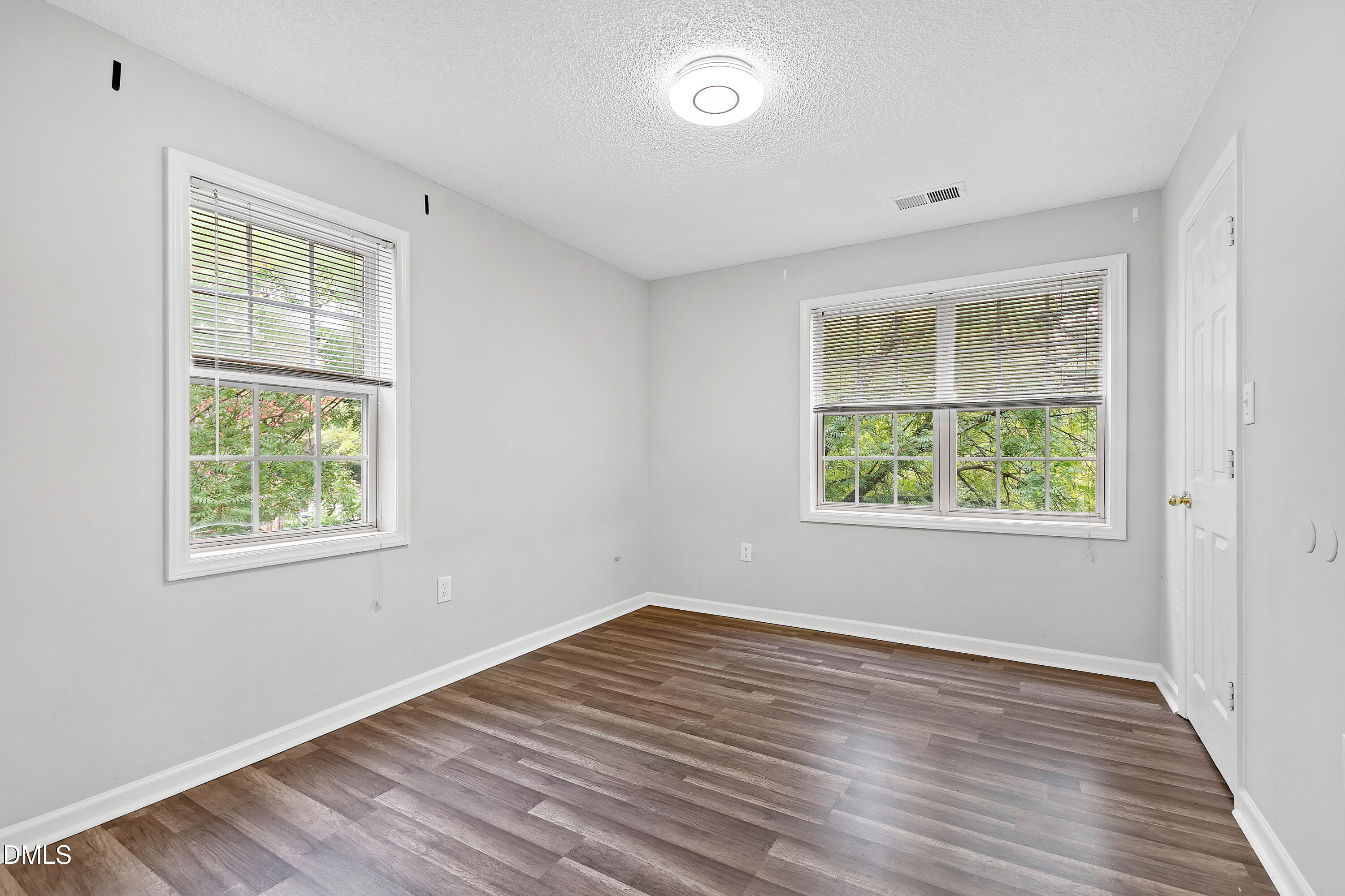 2100 Wolf Tech Lane, Unit 204 Raleigh, NC 27603 - Photo 35 of 40 an empty room with wooden floor and windows