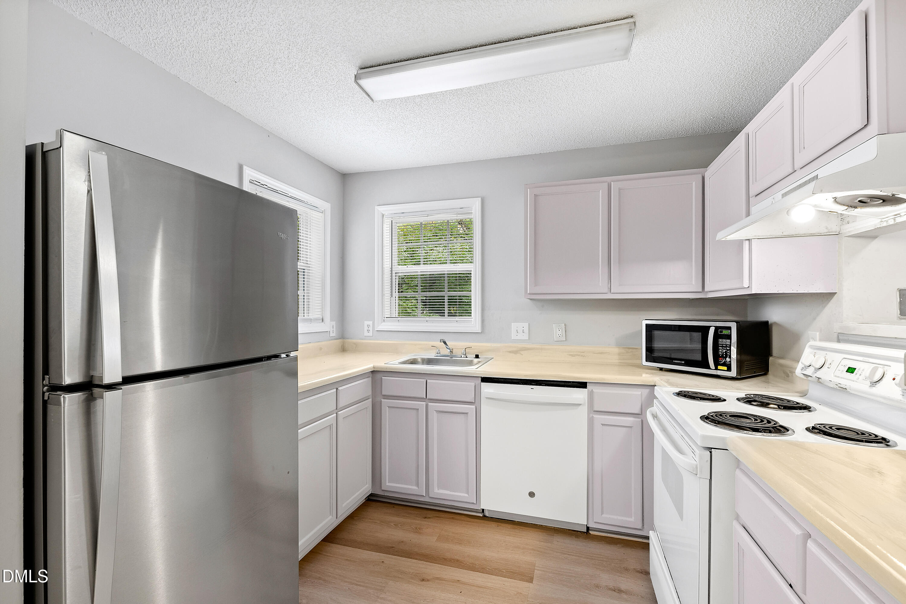 2100 Wolf Tech Lane, Unit 204 Raleigh, NC 27603 - Photo 6 of 40 a kitchen with a refrigerator a stove a sink and a microwave