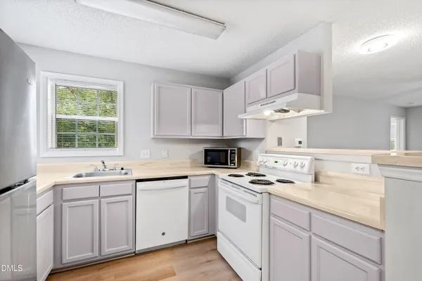a kitchen with cabinets appliances a sink and a window
