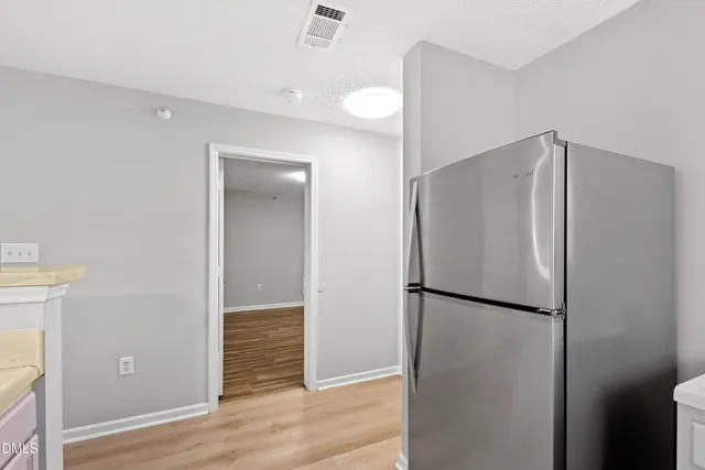 a metallic refrigerator freezer sitting in a kitchen