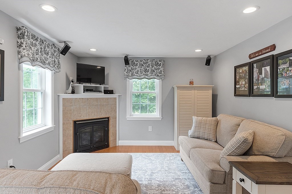 113 Green Road Bolton, MA 01740 - Photo 20 of 41 a living room with furniture a flat screen tv and a fireplace