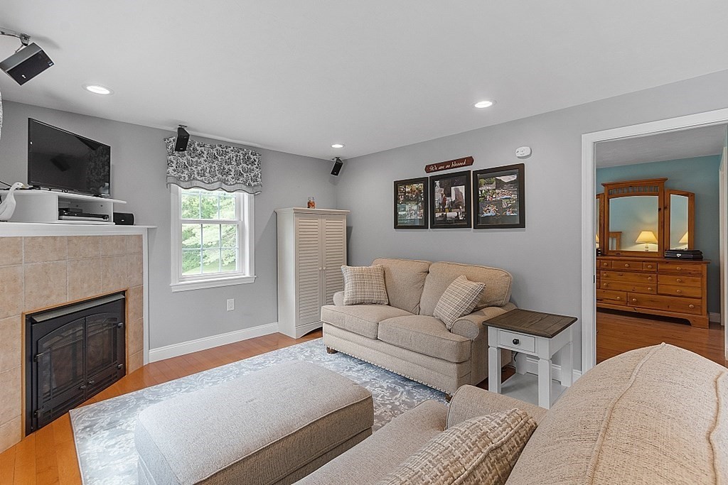 113 Green Road Bolton, MA 01740 - Photo 21 of 41 a living room with furniture a flat screen tv and a fireplace