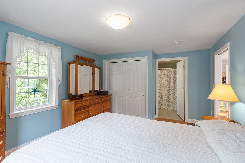 113 Green Road Bolton, MA 01740 - Photo 23 of 41 a bedroom with a bed and a dresser with mirror