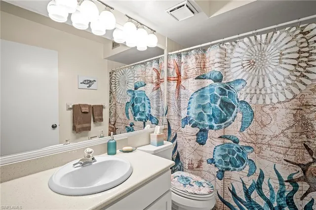 a bathroom with a sink and mirror with toilet