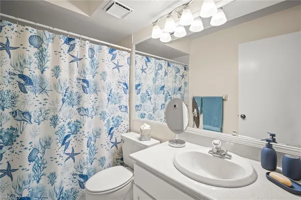 a bathroom with a sink vanity mirror and toilet