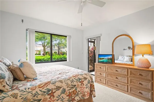 a bedroom with a bed and a dresser with mirror