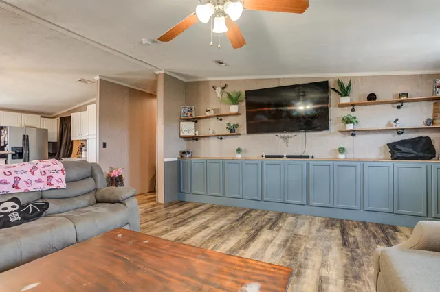a living room with furniture and a ceiling fan