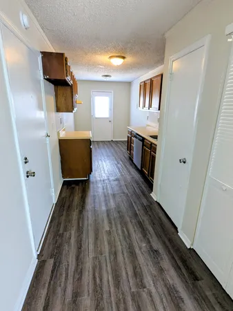a view of a hallway with wooden floor and staircase