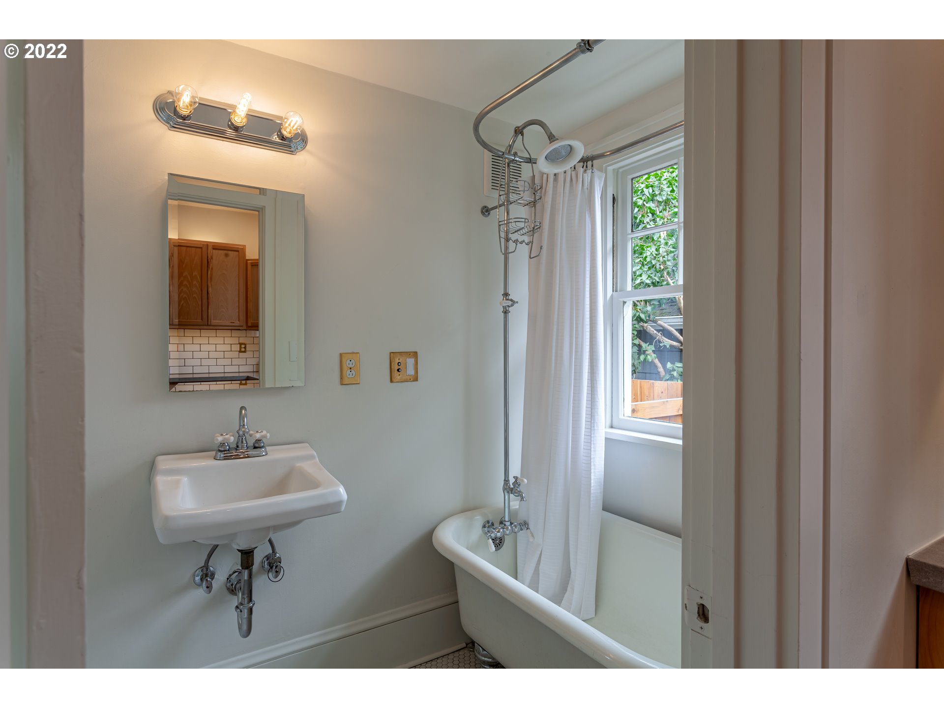 3345 Northeast Holladay Street Portland, OR 97232 - Photo 11 of 32 a bathroom with a sink a light fixture and a mirror
