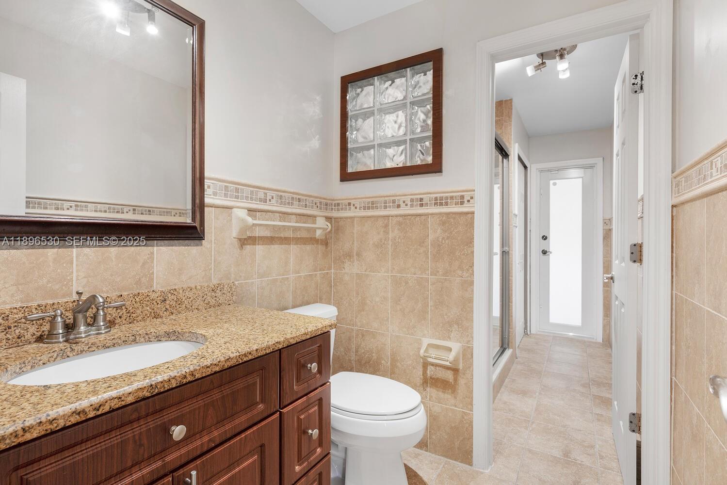 14020 Southwest 38th Street Miami, FL 33175 - Photo 15 of 21 a bathroom with a granite countertop toilet sink and mirror