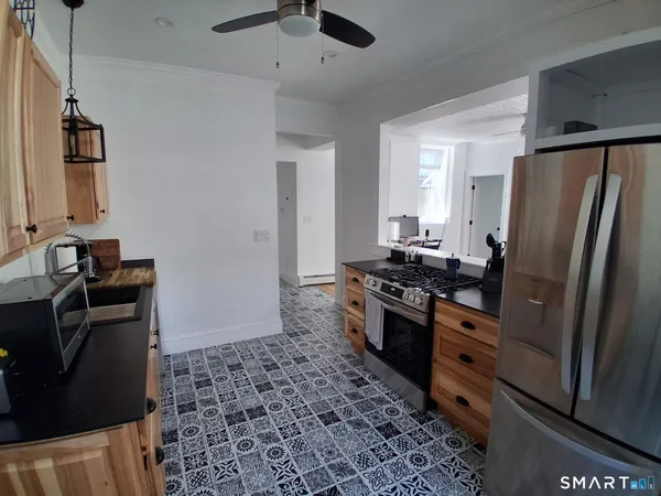 a kitchen with granite countertop a refrigerator stove and sink