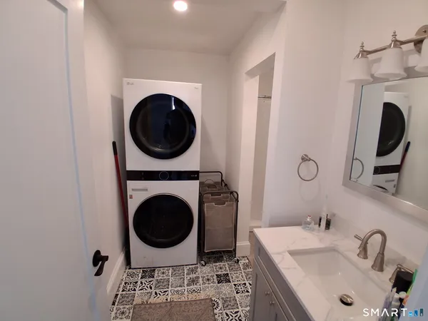 a bathroom with a sink mirror a washer and dryer