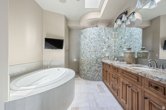 2331 West Entrada Trail, Unit 61 St. George, UT 84770 - Photo 28 of 69 Travertine tile flooring complemented by a dual vanity with a stone countertop and wood-finish cabinetry