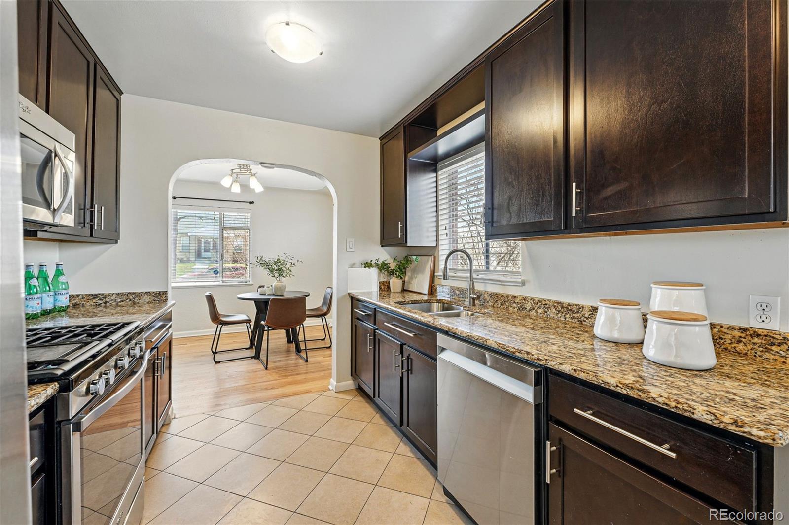 1632 Ulster Street Denver, CO 80220 - Photo 13 of 26 a kitchen with granite countertop stainless steel appliances stove sink and cabinets