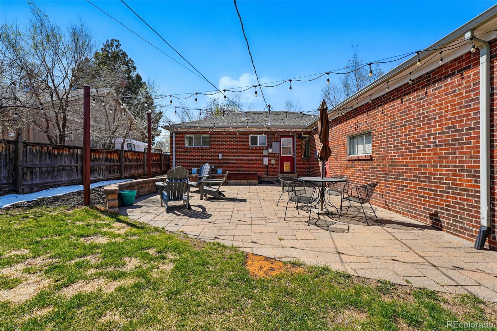 1632 Ulster Street Denver, CO 80220 - Photo 25 of 26 a view of a patio with table and chairs with wooden floor and fence