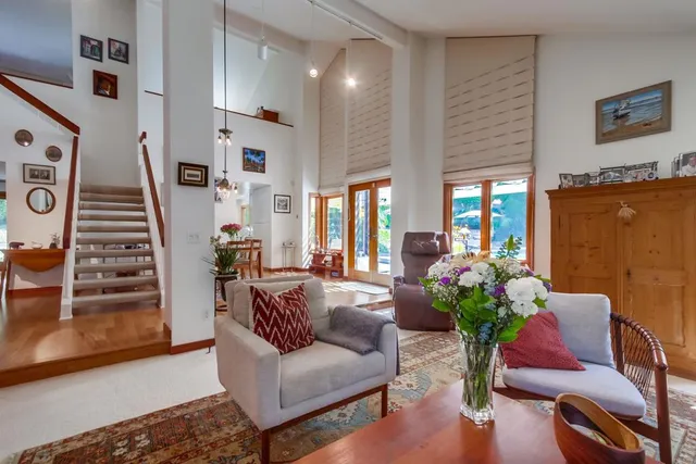 a dining room with wooden floor a rug and a chandelier