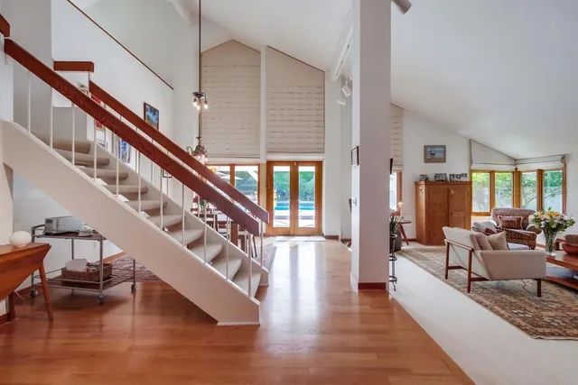 a living room with furniture a bookshelf and a large window