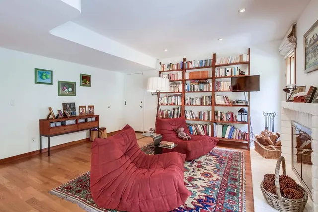 a living room with furniture kitchen view and a wooden floor