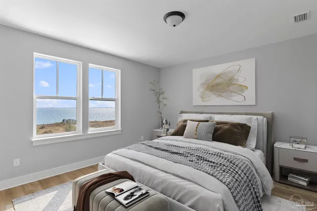 a bedroom with a bed and wooden floor