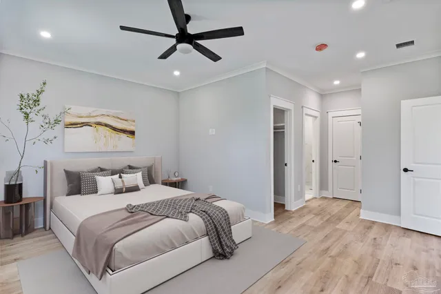 a bedroom with a large bed and a chandelier