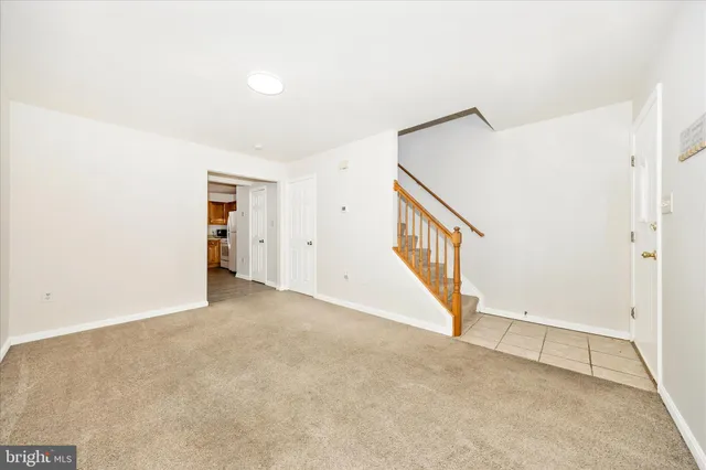 a view of an empty room with wooden floor and entryway