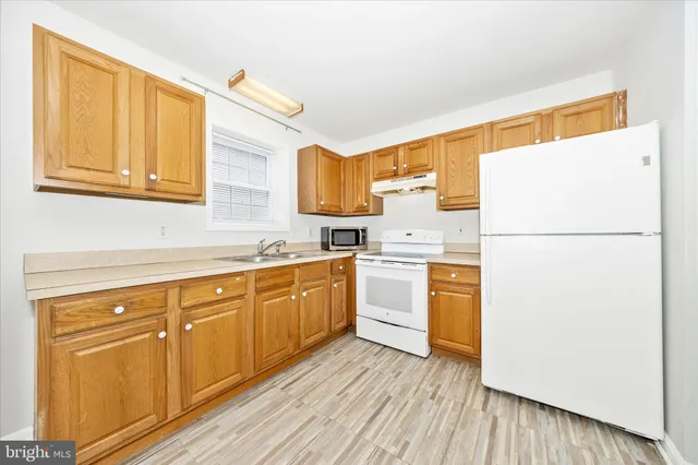 a kitchen with a refrigerator sink and cabinets