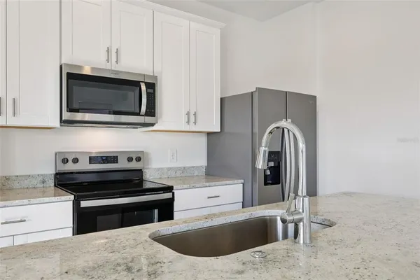 a kitchen with granite countertop a stove and a microwave