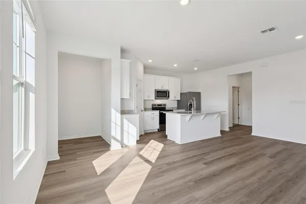 a view of kitchen with kitchen island sink refrigerator and window